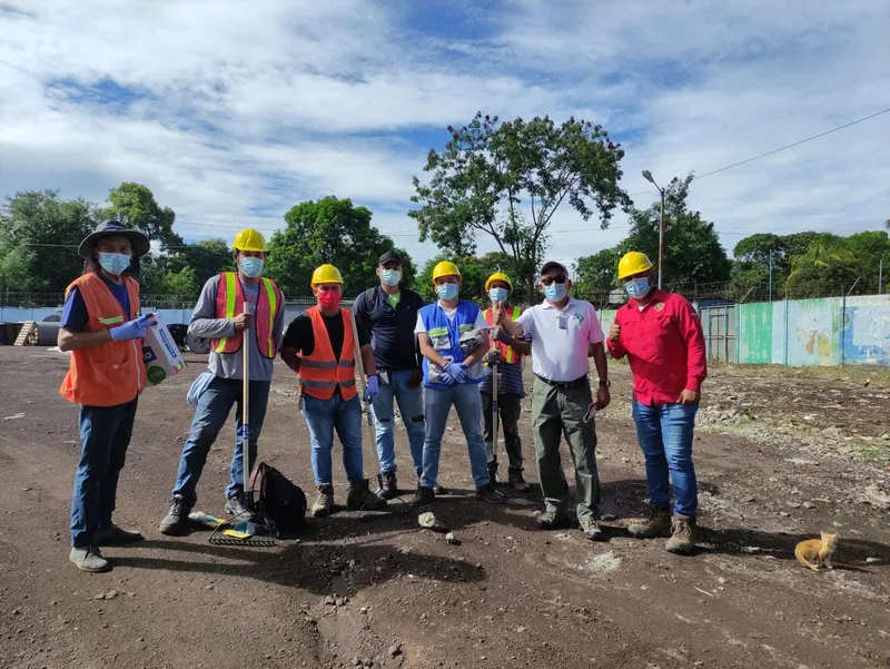 Grupo de personal en exterior junto a un área operativa.